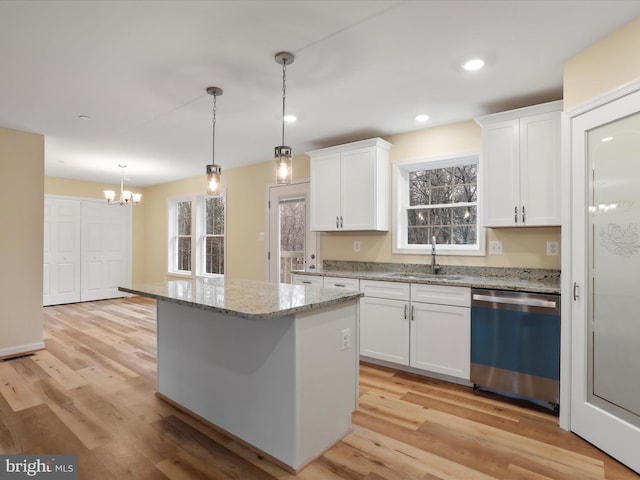 kitchen featuring sink, decorative light fixtures, stainless steel dishwasher, a kitchen island, and white cabinets