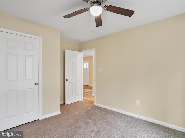 unfurnished bedroom featuring ceiling fan and light carpet