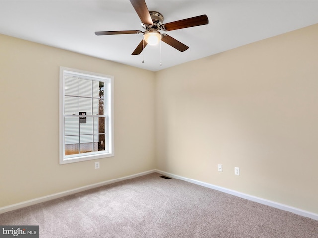 carpeted spare room featuring ceiling fan