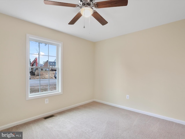 carpeted spare room with ceiling fan