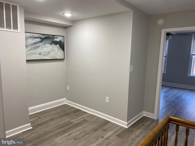 unfurnished room with dark wood-type flooring