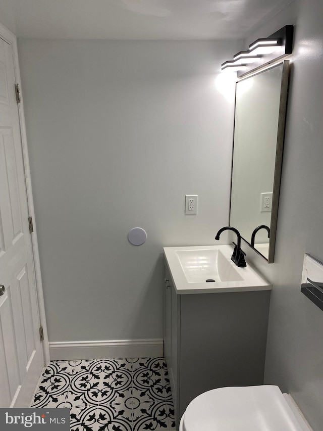 bathroom with tile patterned flooring, vanity, and toilet