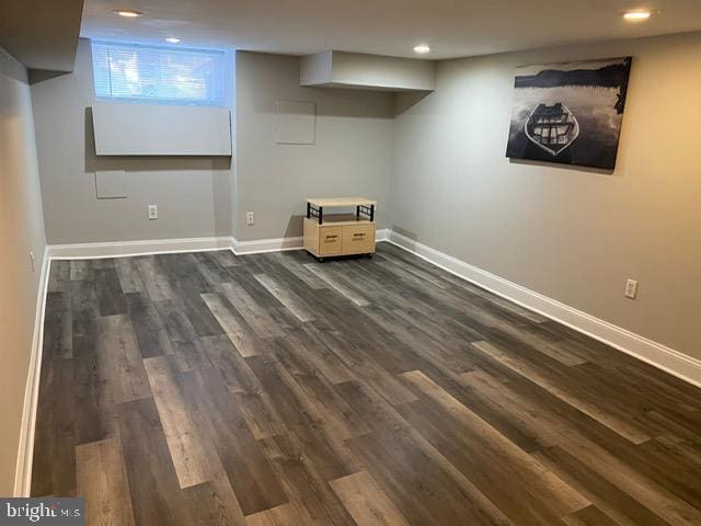 basement with dark hardwood / wood-style flooring