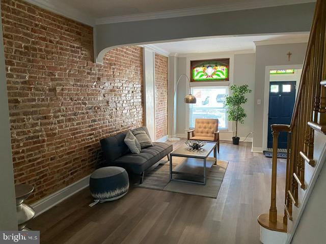 sitting room with ornamental molding, brick wall, and hardwood / wood-style floors