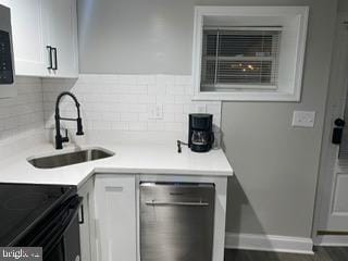 kitchen with appliances with stainless steel finishes, dark hardwood / wood-style floors, sink, white cabinets, and backsplash