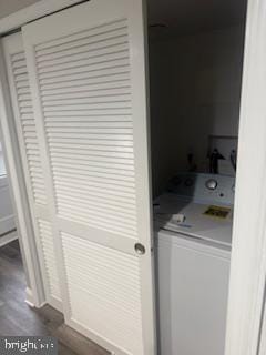 laundry area with dark hardwood / wood-style flooring and washer / dryer