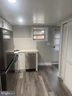 kitchen with dark hardwood / wood-style flooring, stainless steel appliances, and white cabinets