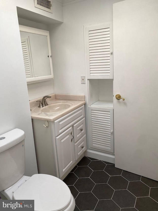 bathroom with vanity, tile patterned flooring, and toilet