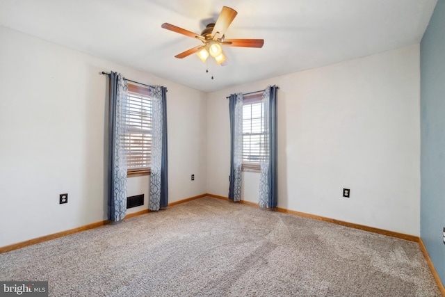 spare room featuring ceiling fan, carpet, visible vents, and baseboards