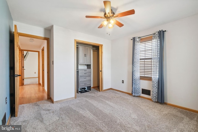 unfurnished bedroom featuring a closet, visible vents, light carpet, ceiling fan, and baseboards