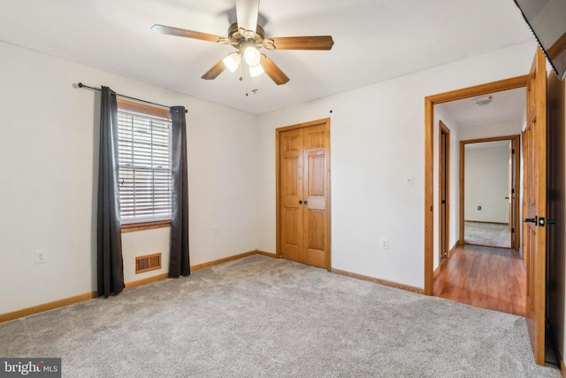 unfurnished bedroom with carpet, visible vents, ceiling fan, and baseboards