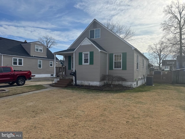 bungalow-style home featuring a front yard, central AC, and fence