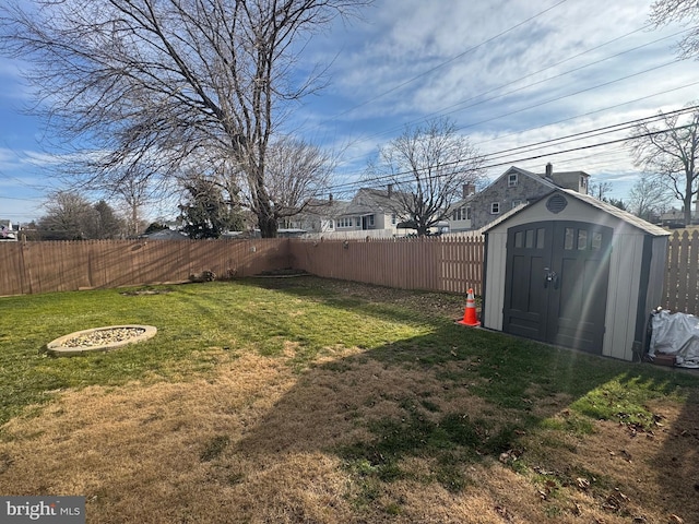 view of yard featuring an outbuilding, a shed, and a fenced backyard