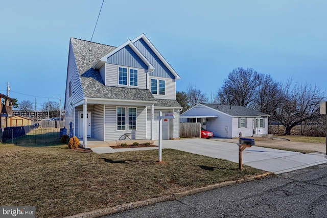 view of front of property with a shingled roof, fence, driveway, board and batten siding, and a front yard