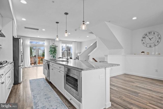 kitchen featuring white cabinetry, a kitchen island with sink, and sink