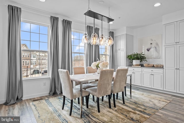 dining area with hardwood / wood-style floors and a notable chandelier