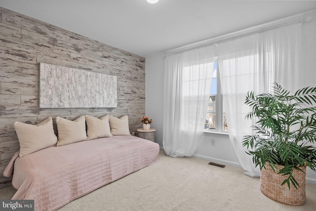 carpeted bedroom with wood walls