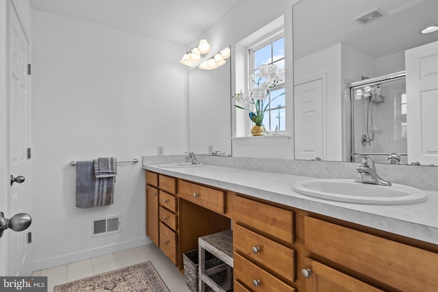 bathroom with an enclosed shower, vanity, and tile patterned floors