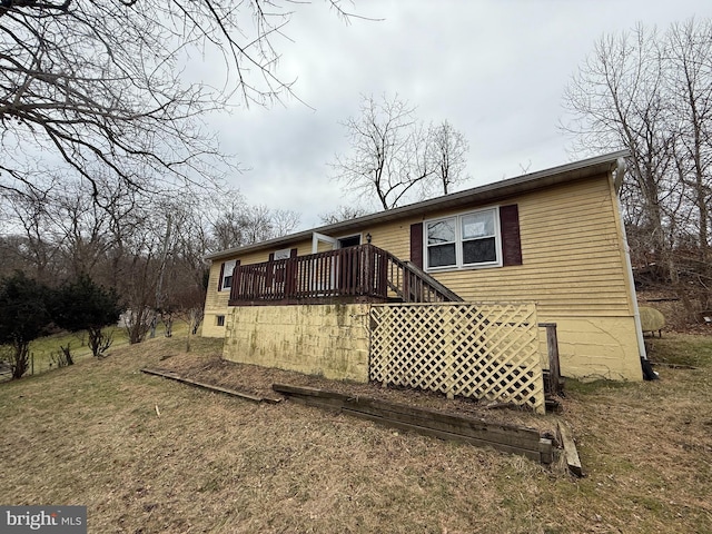 back of property featuring a yard and a deck