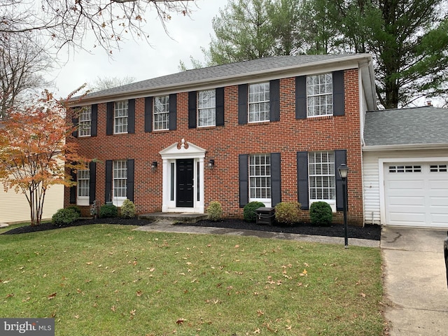 colonial home with a garage and a front lawn