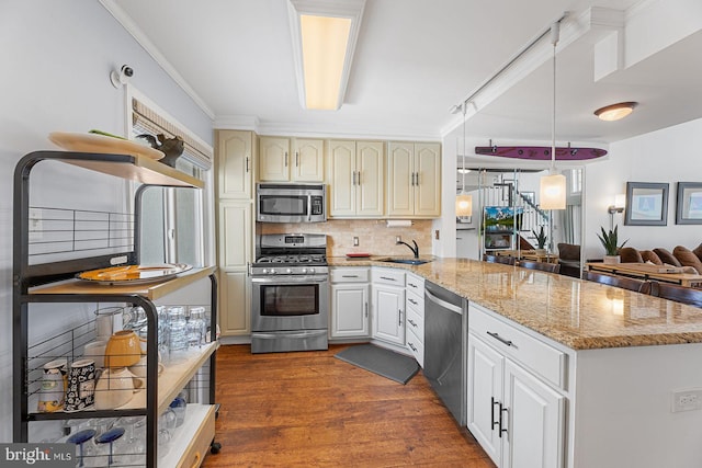 kitchen with sink, dark wood-type flooring, backsplash, stainless steel appliances, and decorative light fixtures