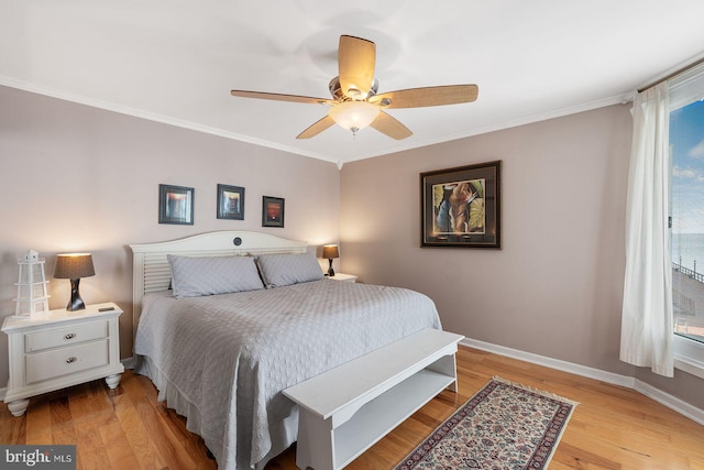 bedroom with crown molding, light hardwood / wood-style floors, and ceiling fan