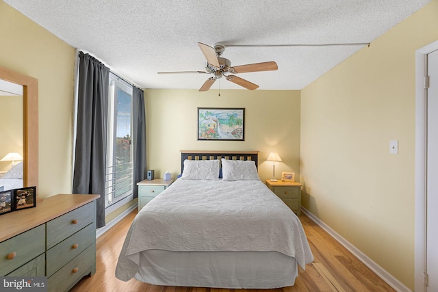 bedroom featuring ceiling fan, a textured ceiling, and light wood-type flooring