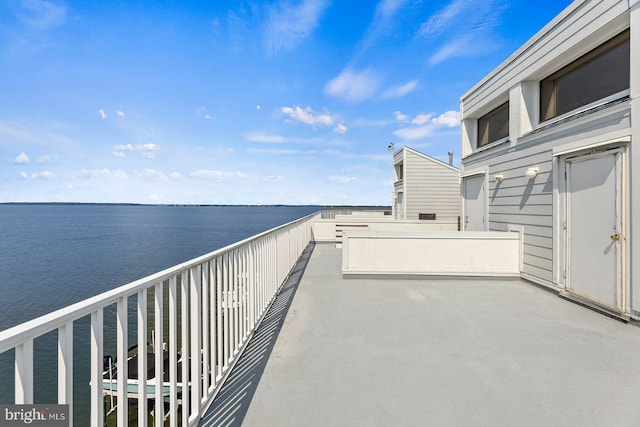 view of patio featuring a balcony and a water view