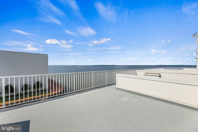 view of patio with a water view and a balcony