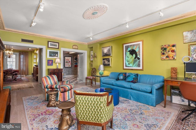 living room with an inviting chandelier, track lighting, and wood-type flooring