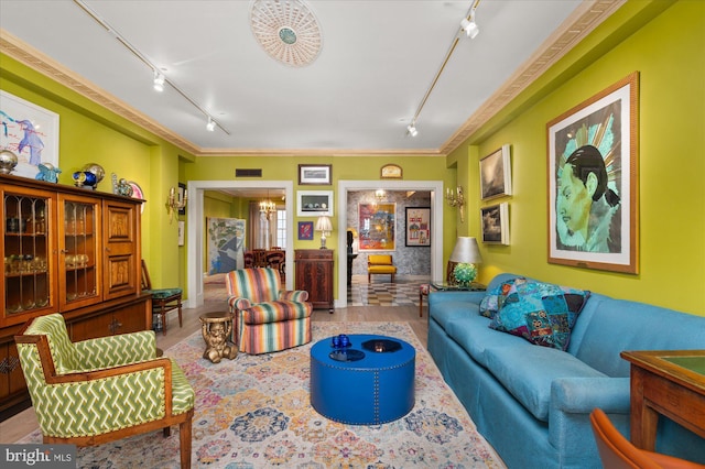 living room with crown molding, track lighting, a notable chandelier, and light hardwood / wood-style floors