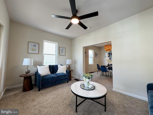 carpeted living room with ceiling fan