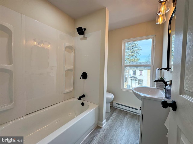 full bathroom featuring hardwood / wood-style flooring, a baseboard heating unit, vanity, shower / washtub combination, and toilet