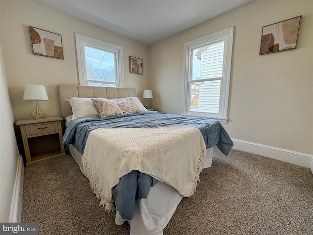 bedroom featuring dark carpet and multiple windows