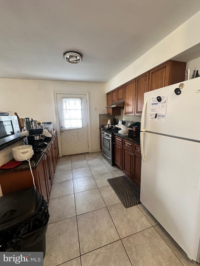 kitchen featuring stainless steel appliances and light tile patterned flooring