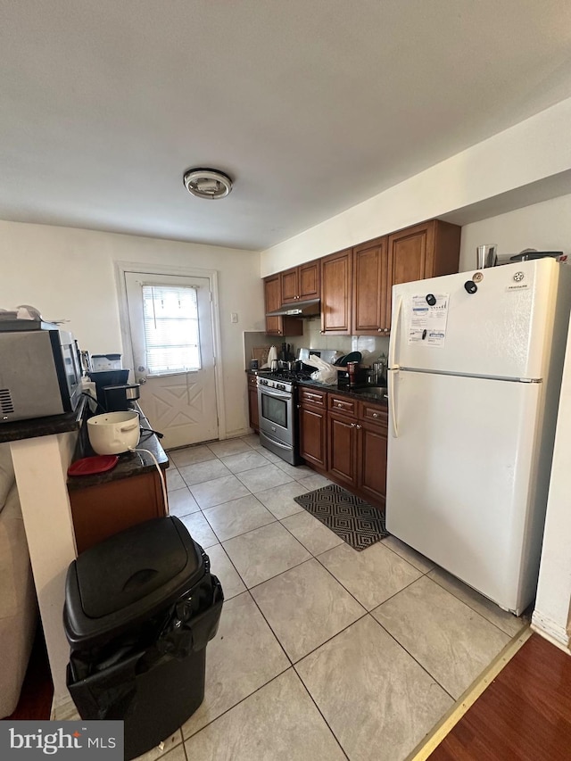 kitchen with light tile patterned flooring and appliances with stainless steel finishes