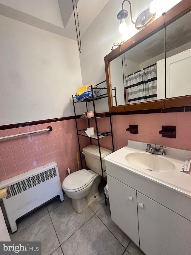 bathroom with tile patterned flooring, vanity, radiator heating unit, and toilet