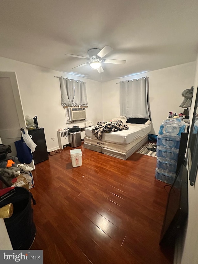 bedroom with cooling unit, dark wood-type flooring, and ceiling fan