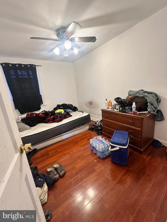 bedroom with dark hardwood / wood-style floors and ceiling fan