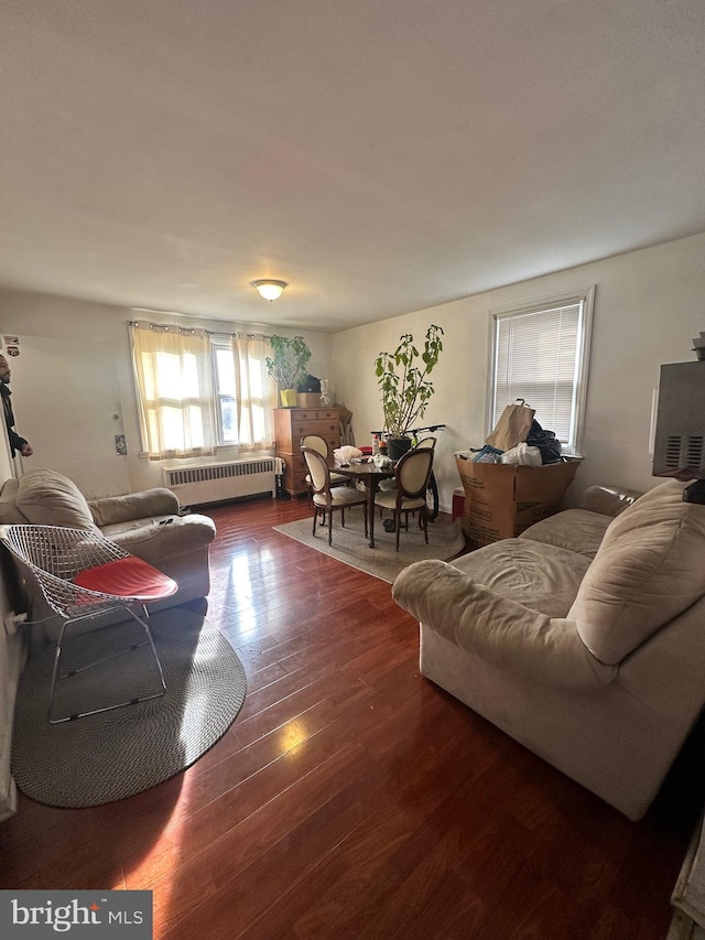 living room with dark hardwood / wood-style floors and radiator heating unit