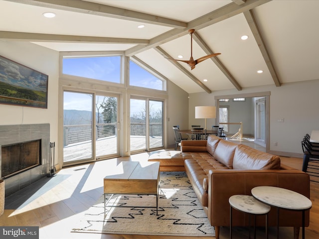 living room featuring high vaulted ceiling, beamed ceiling, a tiled fireplace, and a mountain view