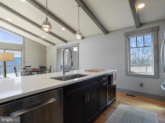 kitchen with wine cooler, vaulted ceiling with beams, light countertops, stainless steel dishwasher, and a sink