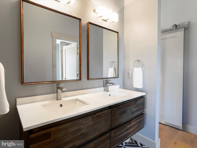 bathroom featuring double vanity, a sink, and wood finished floors