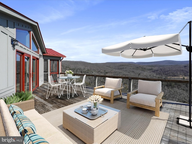 wooden deck featuring an outdoor hangout area, outdoor dining space, and a mountain view