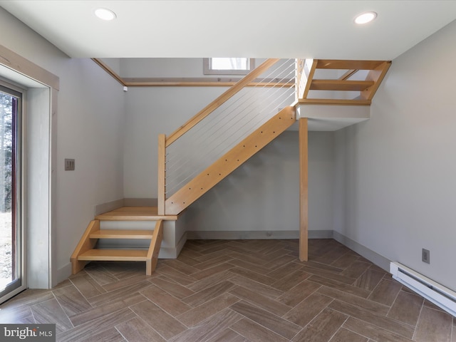 staircase with a baseboard radiator, baseboards, and recessed lighting