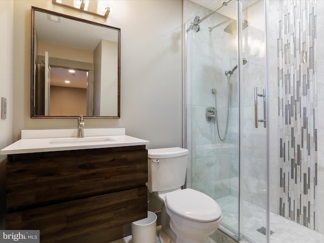 full bathroom featuring a stall shower, vanity, and toilet