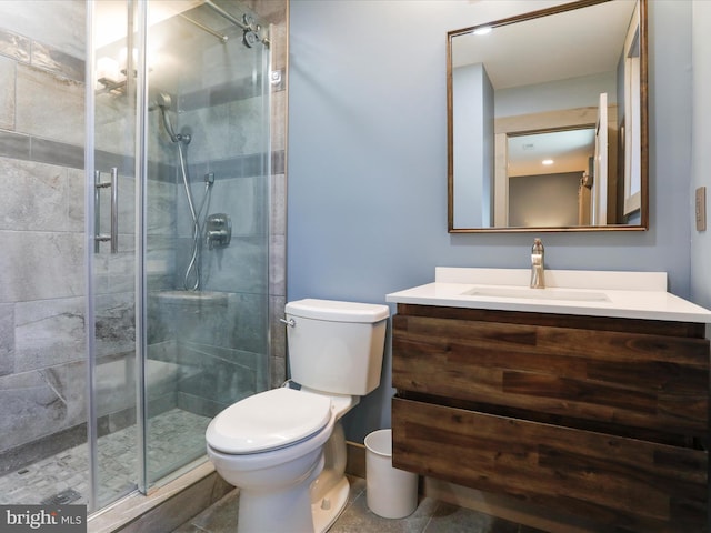 bathroom featuring a shower stall, toilet, and vanity