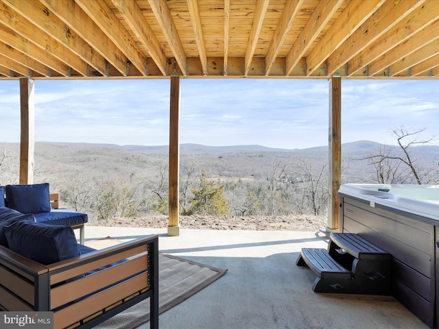 view of patio / terrace featuring a hot tub and a mountain view