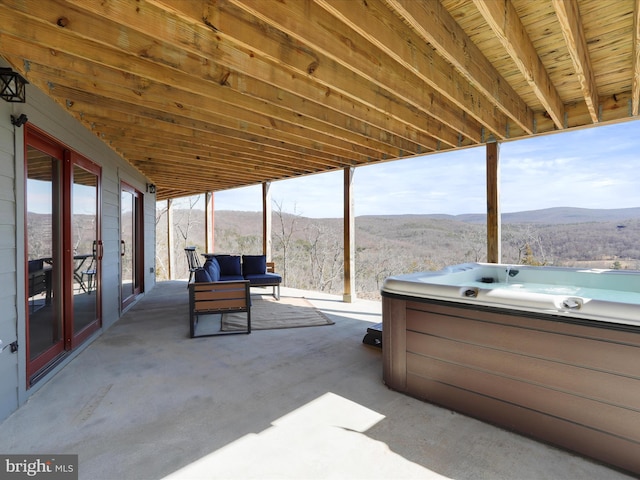 view of patio / terrace with a mountain view and a hot tub