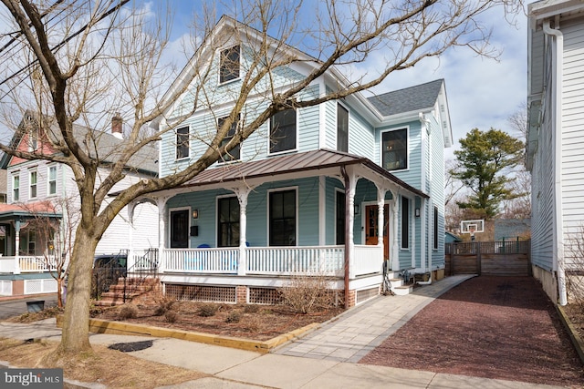 view of front facade featuring a porch, a standing seam roof, and metal roof